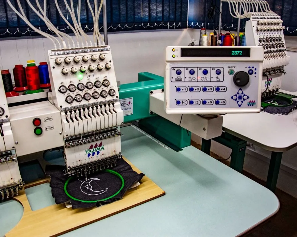 Commercial embroidery machine stitching a logo